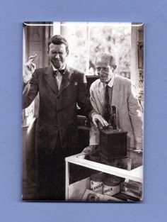 two men standing next to each other in front of a box