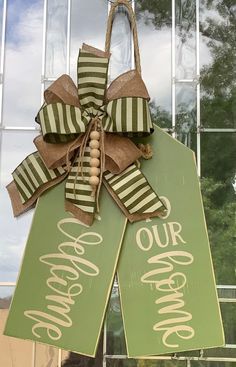 a green and white door hanger with the words our welcome home written on it