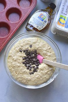 a cookie dough in a bowl with chocolate chips on top and baking utensils next to it