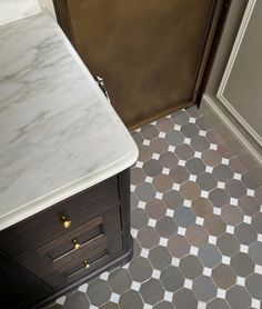 a bathroom with white and brown tile on the floor