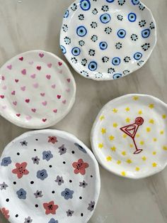 three plates with different designs on them sitting on a marble table top, one has an eyeball design and the other has a pink flamingo