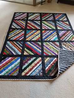 a multicolored quilt is laying on the floor