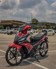 a red and black motorcycle parked in a parking lot