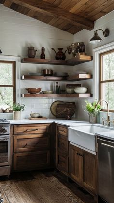 a kitchen with wooden cabinets and open shelving above the sink is filled with dishes