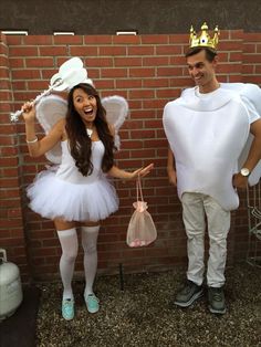 a man and woman in costumes standing next to a brick wall with bags on their backs