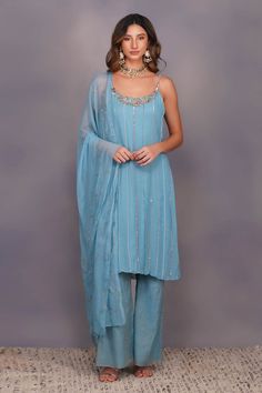 Sky blule embellished slip kurta in shimmer georgette with neckline adorned with floral work. Paired with tissue chanderi boot cut pant and a semi sheer sequins dupatta.
Component: 3
Embellished
Neckline: Round
Sleeve Length: Sleeveless
Fabric: Viscose Georgette, Tissue Chanderi
Color: Blue
Multicolor thread work on neckline Bootcut pant - Aza Fashions Turquoise Rose, Floral Work, Traditional Indian Outfits, Smart Outfit, Indian Fashion Designers, Kurta With Pants, Embroidered Tunic, Pant Set, Indian Design