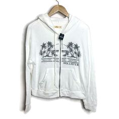 Hollister Embroidered Zip Up Hoodie Sweatshirt Jacket Brand New With Tags! Size: M 56% Cotton, 41% Polyester, 3% Viscose Gray Embroidered Tropical Scene & Logo. 2 Front Waist Pockets. Drawstring Hoodie. Super Soft Fleece Inside. Machine Wash. Chest:(Under Arm To Under Arm) 21.5” Flat Across Waist: 21” Flat Across Sleeve Length: 25” Jacket Length:(Top Shoulder To Hem) 21.5” 1022 White Casual Hoodie Top, Casual White Hoodie Top, White Relaxed Fit Casual Hoodie, White Casual Hoodie For Spring, Reworked Hoodie, Hollister Sweatshirt, Hollister Logo, White Pullover Sweater, Grey Cropped Hoodie