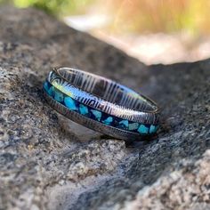 This is a USA-made comfort fit 6mm wide Damascus Steel with a rounded top profile, acid etch, and a 2-millimeter turquoise & lapis lazuli inlay. It is very comfortable to wear with a rounded comfort fit design. This ring is hand-finished & designed by jewelry artisans who have a passion for unique jewelry & uncompromising quality. 6mm Damascus steel Acid-etched 2mm center turquoise & lapis lazuli Inside comfort fit design SKU: DD-WHT-6HR12G-Turq-Lps Made In The USA Box Color May Stamped Turquoise Rings For Gifts, Blue Round Etched Jewelry, Blue Etched Round Jewelry, Damascus Ring, Damascus Steel Ring, Box Color, Damascus Steel, Steel Ring, Damascus