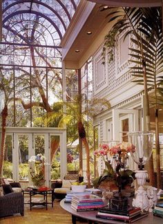 the inside of a house with lots of windows and plants in it's center