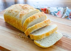 sliced loaf of bread sitting on top of a wooden cutting board