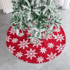 a red and white snowflaked christmas tree skirt on a round floor mat