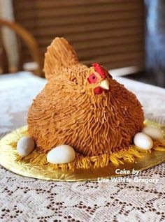 a cake shaped like a chicken sitting on top of a table with eggs in it