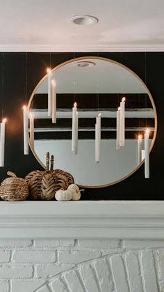 a mirror and some candles on a mantle