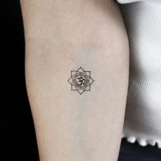 a woman's arm with a small tattoo design on the back of her left arm