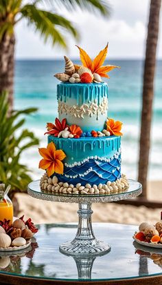 a blue and white cake sitting on top of a glass table next to the ocean