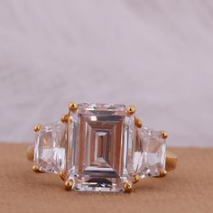 an emerald cut diamond ring with three baguets