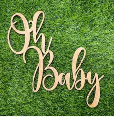 a wooden sign that says oh baby on green grass