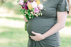 a pregnant woman holding a bouquet of flowers