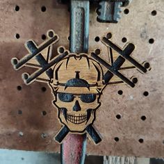 a wooden skull and crossbones on a wall with holes in the middle that are connected to two wrenches