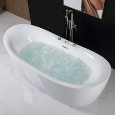 a white bath tub sitting on top of a bathroom counter next to a faucet