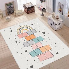 a white area rug with colorful blocks and hearts in the middle on a wooden floor