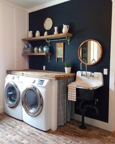 a washer and dryer sitting in a room next to a sink with a mirror on the wall