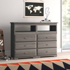 a grey dresser with drawers and a guitar in front of it on an orange rug