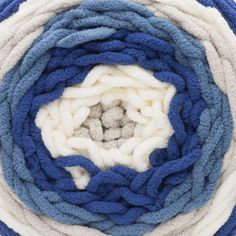 blue, white and grey yarn is arranged in a spiral pattern on top of each other