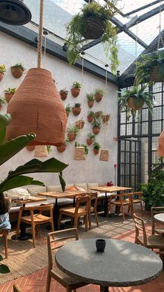 an indoor cafe with plants hanging from the ceiling