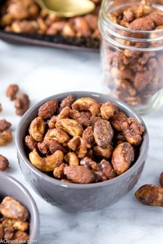 two bowls filled with nuts on top of a table