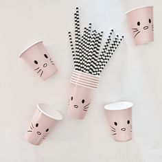 pink cups with black and white striped straws in the shape of cats