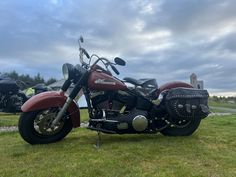 a red motorcycle parked on top of a lush green field