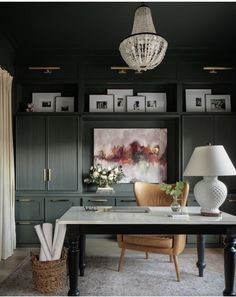 a room with green cabinets and a chandelier hanging from the ceiling above it