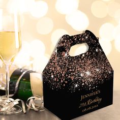 a black and gold party bag next to a glass of champagne