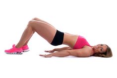 a woman in pink top and black shorts laying on the ground