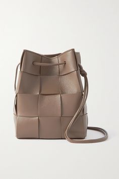 "It almost becomes a blank canvas for the various processes and for playing around with colors, styles, sizes and construction techniques," says Bottega Veneta of its iconic intrecciato. Assembled in a boxy shape with drawstring ties, this 'Cassette' bucket bag is expertly crafted from soft leather. Use the dust cover between wears or fill it with rolled tees to maintain the shape even longer. Luxury Beige Bucket Bag With Intrecciato Weave, Designer Rectangular Bucket Bag With Intrecciato Weave, Designer Square Leather Bucket Bag, Bottega Veneta Cassette, Small Buckets, Bottega Veneta Bags, Bottega Veneta Intrecciato, Metal Accessories, Leather Weaving