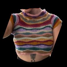 a woman wearing a multicolored knitted top with an open back and short sleeves