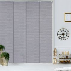 a living room scene with focus on the blinds in the window, and a clock