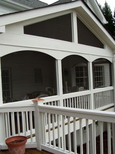 a porch with white railings and windows