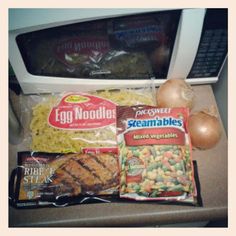 an open microwave oven filled with food next to eggs, meat and veggies