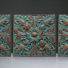 three pieces of art that look like they are made out of metal and wood with flowers on them