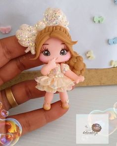 a hand holding a small doll with bubbles around it