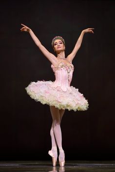 the ballerina is dressed in pink and white