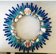 a wreath made out of blue sticks and seashells on a wall in a room