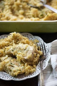 a white plate topped with chicken and rice next to a green casserole dish