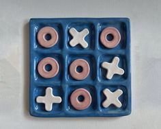 a blue plate with pink and white doughnuts in it on top of a table