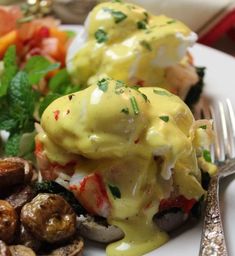 a white plate topped with eggs benedict and mushrooms