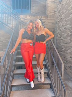 two women in matching outfits standing on stairs