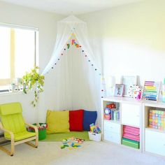 a child's playroom with white curtains and colorful furniture