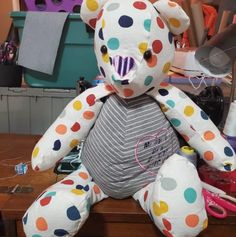 a polka dot teddy bear sitting on top of a wooden table